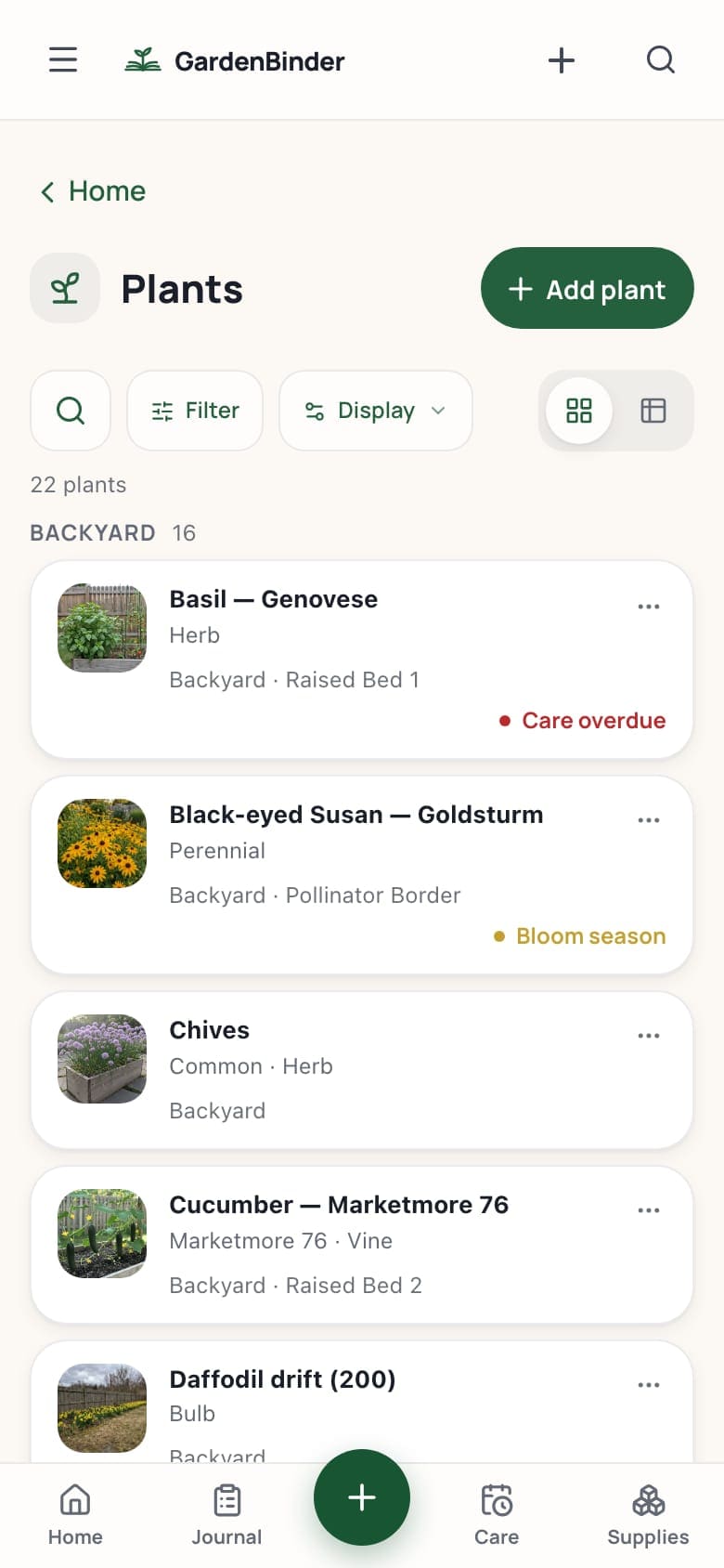 The plant list on a phone: each plant a photo card with its name, its type and its bed, and a status in the corner when it is in bloom or its care is overdue